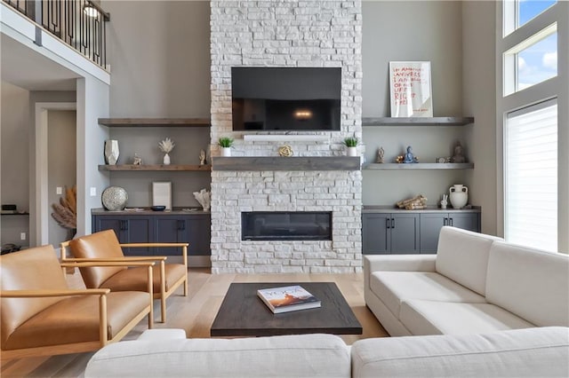 1113 Hummingbird Ct, Greenwood, MO 64034 - living area with a stone fireplace, wood finished floors, and a towering ceiling