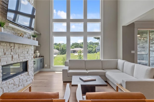 1113 Hummingbird Ct, Greenwood, MO 64034 - living area featuring light wood finished floors, a fireplace, and a towering ceiling