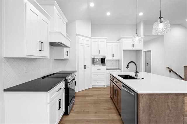 3932 SW Flinkrock Dr, Lees Summit, MO 64082 - kitchen featuring appliances with stainless steel finishes, light wood-style floors, backsplash, white cabinets, and decorative light fixtures