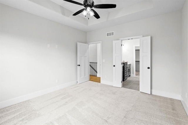 3932 SW Flinkrock Dr, Lees Summit, MO 64082 - unfurnished bedroom featuring light carpet, a tray ceiling, and ceiling fan