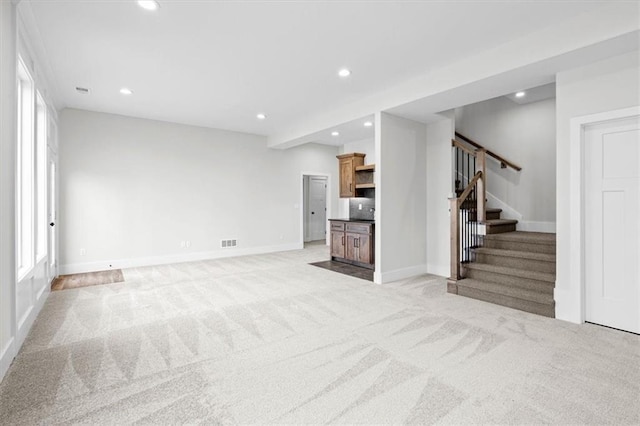 3932 SW Flinkrock Dr, Lees Summit, MO 64082 - unfurnished living room featuring recessed lighting, light carpet, stairs, and healthy amount of natural light