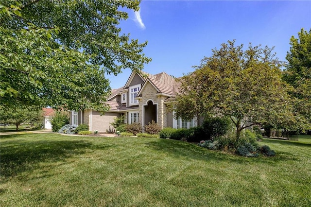 1021 SW Summit Falls Dr, Lees Summit, MO 64081 - view of front of property with stone siding, a front lawn, and a garage