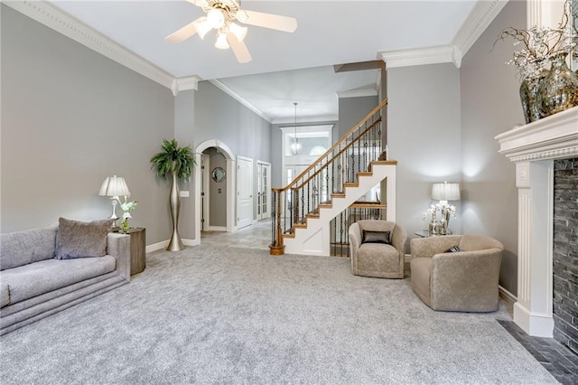 1021 SW Summit Falls Dr, Lees Summit, MO 64081 - living area with ornamental molding, stairs, carpet, ceiling fan, and arched walkways