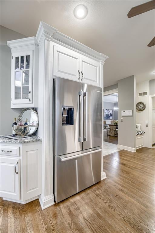 1021 SW Summit Falls Dr, Lees Summit, MO 64081 - kitchen featuring stainless steel fridge with ice dispenser, a ceiling fan, white cabinetry, and light wood-style flooring