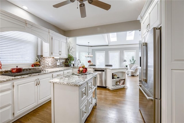 1021 SW Summit Falls Dr, Lees Summit, MO 64081 - kitchen featuring stainless steel appliances, a peninsula, white cabinets, tasteful backsplash, and ceiling fan