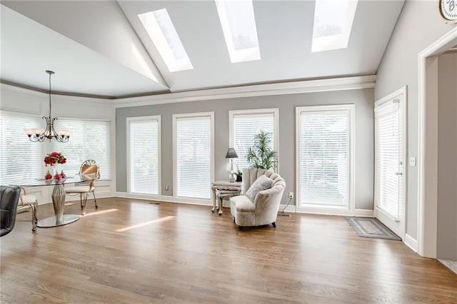 1021 SW Summit Falls Dr, Lees Summit, MO 64081 - living area featuring vaulted ceiling, ornamental molding, wood finished floors, a chandelier, and a skylight