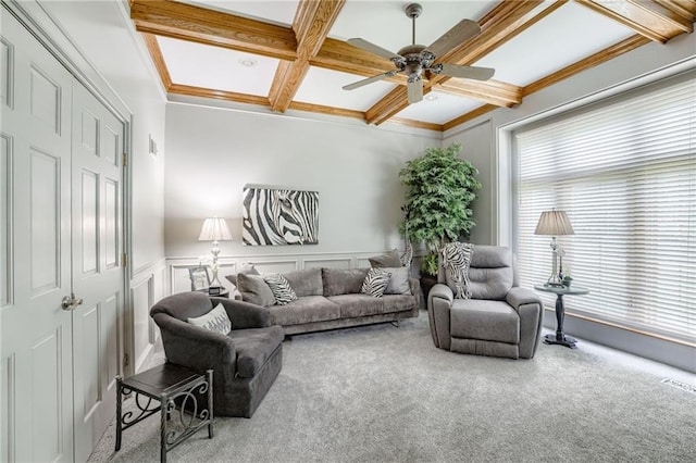1021 SW Summit Falls Dr, Lees Summit, MO 64081 - carpeted living room featuring coffered ceiling, a ceiling fan, beamed ceiling, crown molding, and a wainscoted wall