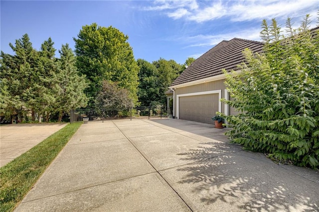 1021 SW Summit Falls Dr, Lees Summit, MO 64081 - view of property exterior featuring concrete driveway, a tile roof, and an attached garage