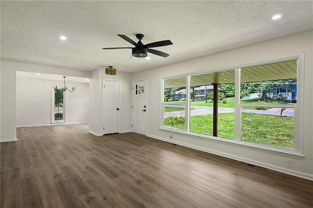 2415 E 126th St, Kansas City, MO 64146 - unfurnished living room featuring a textured ceiling, dark wood-style flooring, a ceiling fan, recessed lighting, and a chandelier