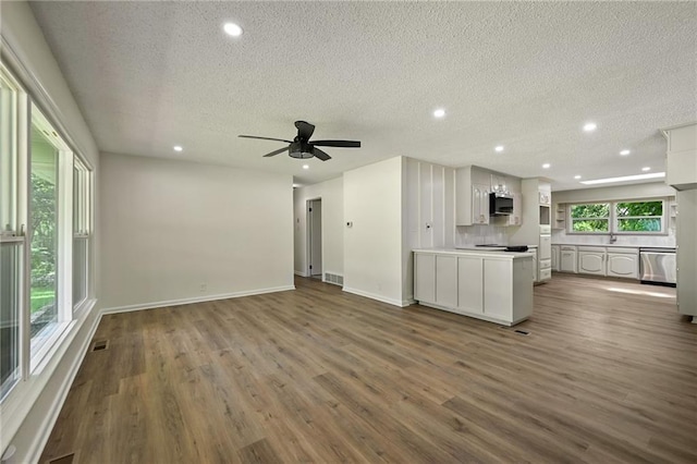 2415 E 126th St, Kansas City, MO 64146 - unfurnished living room featuring a textured ceiling, recessed lighting, dark wood-style flooring, and ceiling fan