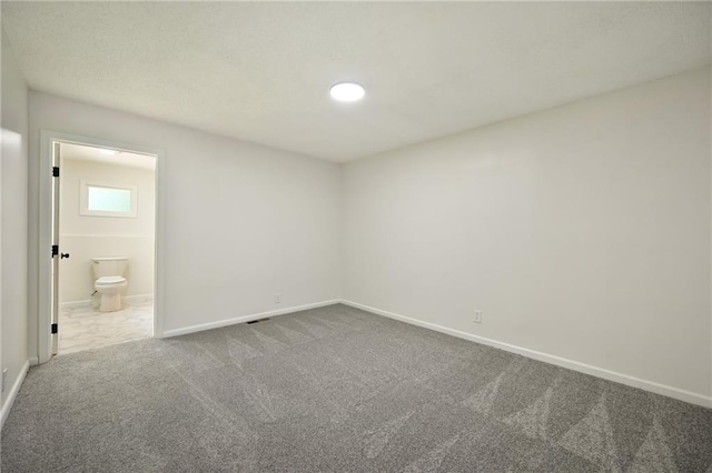 2415 E 126th St, Kansas City, MO 64146 - unfurnished bedroom featuring dark colored carpet and connected bathroom