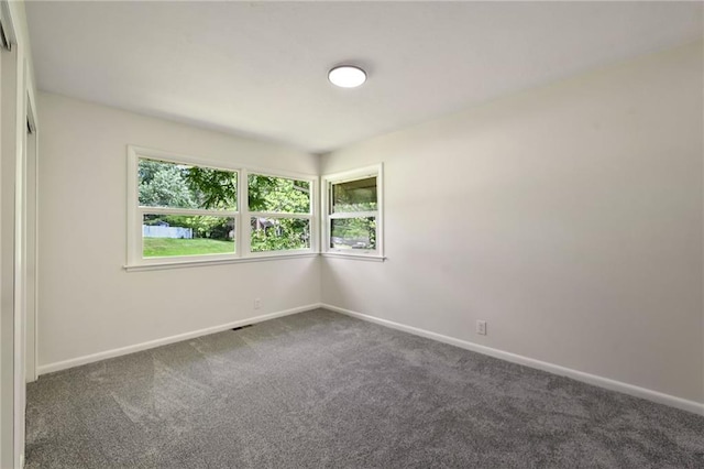 2415 E 126th St, Kansas City, MO 64146 - spare room with dark colored carpet and baseboards