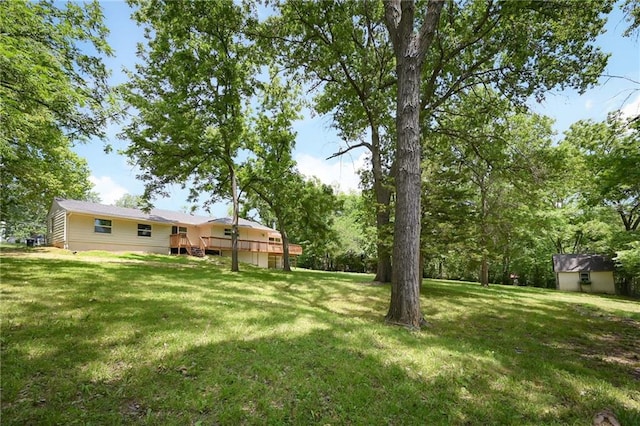 2415 E 126th St, Kansas City, MO 64146 - view of grassy yard featuring a deck and an outbuilding