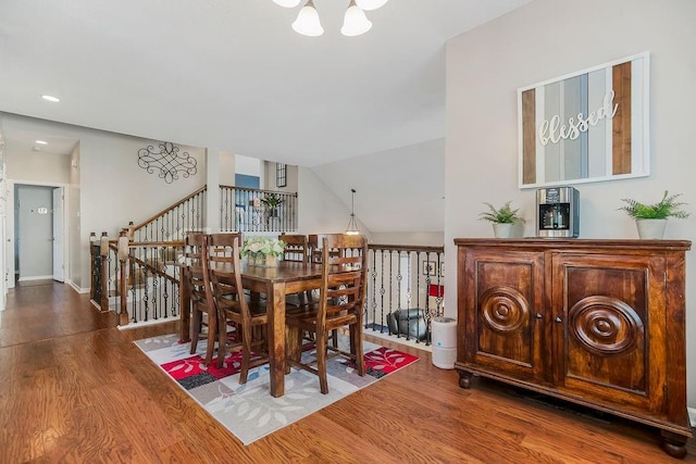 1912 Sequoia Dr, Raymore, MO 64083 - dining space with a chandelier, wood finished floors, and vaulted ceiling
