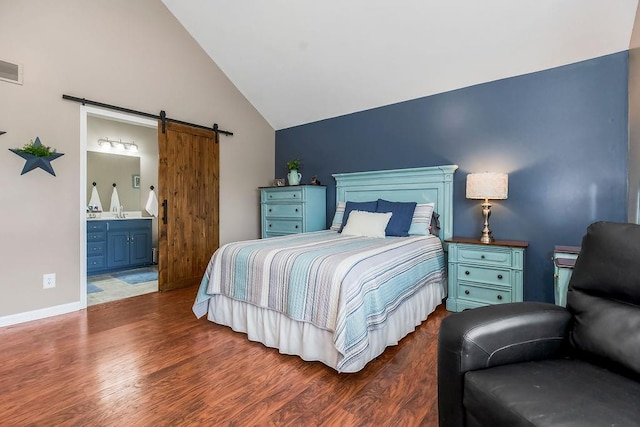 1912 Sequoia Dr, Raymore, MO 64083 - bedroom with a barn door, wood finished floors, ensuite bath, and high vaulted ceiling
