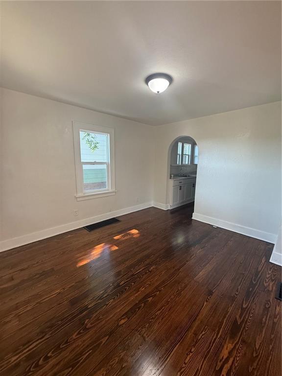 2010 N 2nd St, Saint Joseph, MO 64505 - empty room featuring arched walkways and dark wood finished floors
