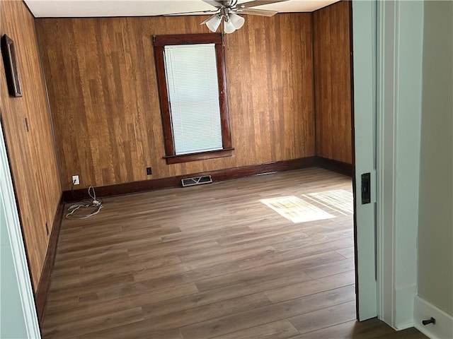 895 Cloud Rd, Salina, KS 67436 - spare room featuring a ceiling fan, wood finished floors, and wood walls