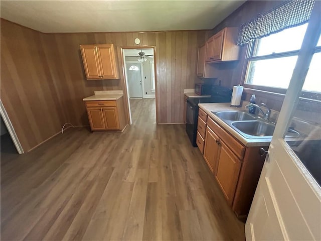 895 Cloud Rd, Salina, KS 67436 - kitchen featuring light wood finished floors, light countertops, black range with electric cooktop, a ceiling fan, and wood walls