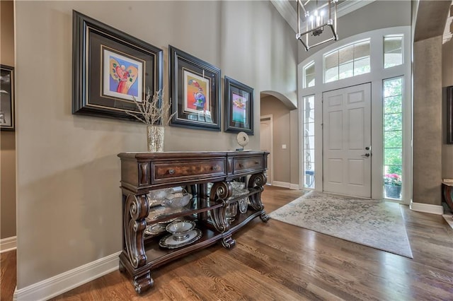 9638 Zarda Dr, Lenexa, KS 66227 - foyer entrance featuring wood finished floors, arched walkways, a towering ceiling, and a chandelier