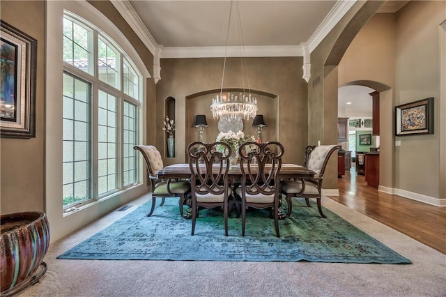 9638 Zarda Dr, Lenexa, KS 66227 - dining room with crown molding, a chandelier, arched walkways, carpet, and wood finished floors