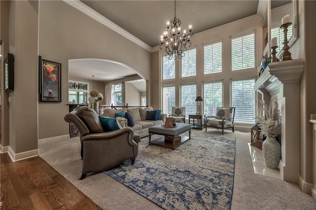 9638 Zarda Dr, Lenexa, KS 66227 - living area featuring a high ceiling, arched walkways, a chandelier, ornamental molding, and carpet floors