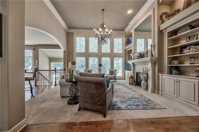 9638 Zarda Dr, Lenexa, KS 66227 - living room with a chandelier, arched walkways, ornamental molding, a fireplace, and wood finished floors