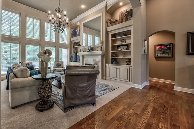 9638 Zarda Dr, Lenexa, KS 66227 - living area with ornamental molding, a high ceiling, a chandelier, built in shelves, and a fireplace