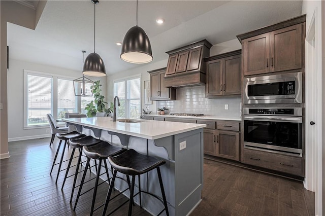 1527 SW Arbor Falls Dr, Lees Summit, MO 64082 - kitchen with appliances with stainless steel finishes, vaulted ceiling, a kitchen island with sink, light countertops, and decorative backsplash