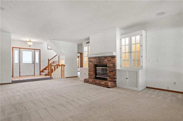 13109 W 65th St, Shawnee, KS 66216 - unfurnished living room featuring carpet, stairway, and a brick fireplace