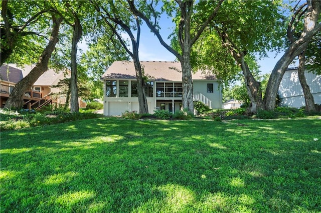 13109 W 65th St, Shawnee, KS 66216 - back of property with stairway, a sunroom, a garage, and a lawn