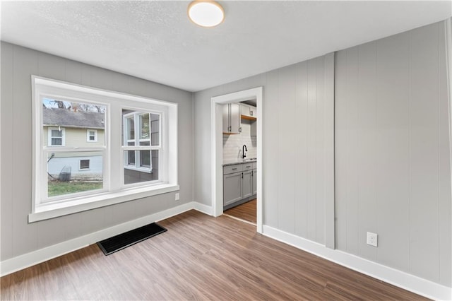 320 N Cedar Ave, Independence, MO 64053 - unfurnished room featuring dark wood finished floors and a textured ceiling