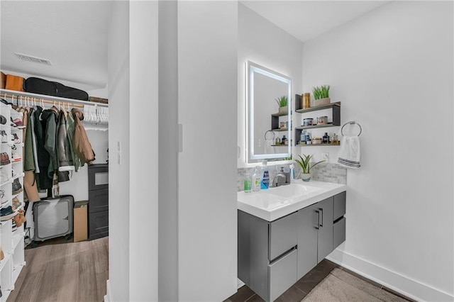 5015 Walnut St Unit A, Kansas City, MO 64112 - bathroom featuring vanity, tasteful backsplash, and a walk in closet