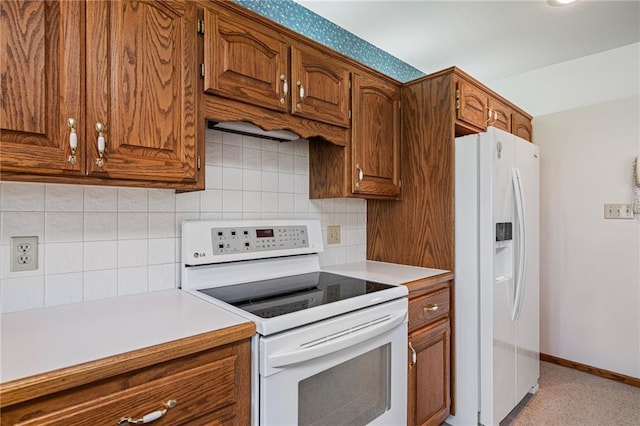 1001 E Park Rd, Garnett, KS 66032 - kitchen with white appliances, brown cabinets, light countertops, and tasteful backsplash