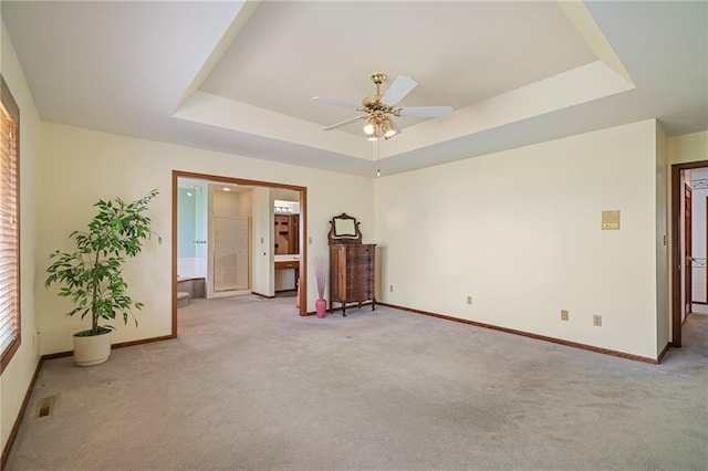 1001 E Park Rd, Garnett, KS 66032 - carpeted empty room featuring a tray ceiling and a ceiling fan