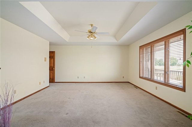1001 E Park Rd, Garnett, KS 66032 - spare room with light colored carpet, a ceiling fan, and a tray ceiling