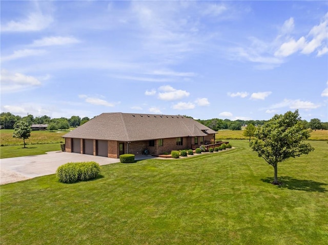 1001 E Park Rd, Garnett, KS 66032 - view of front of home featuring concrete driveway, a front lawn, an attached garage, and brick siding