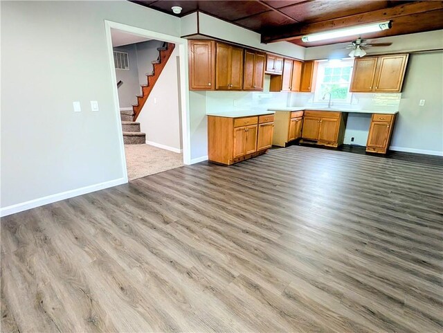 710 E Vine St, Iola, KS 66749 - kitchen with wood finished floors, light countertops, dishwashing machine, ceiling fan, and brown cabinetry