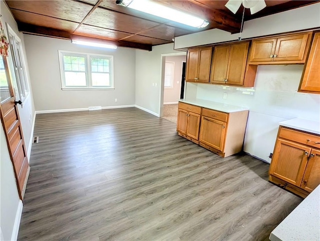 710 E Vine St, Iola, KS 66749 - kitchen with brown cabinets, light countertops, light wood-type flooring, a ceiling fan, and beam ceiling