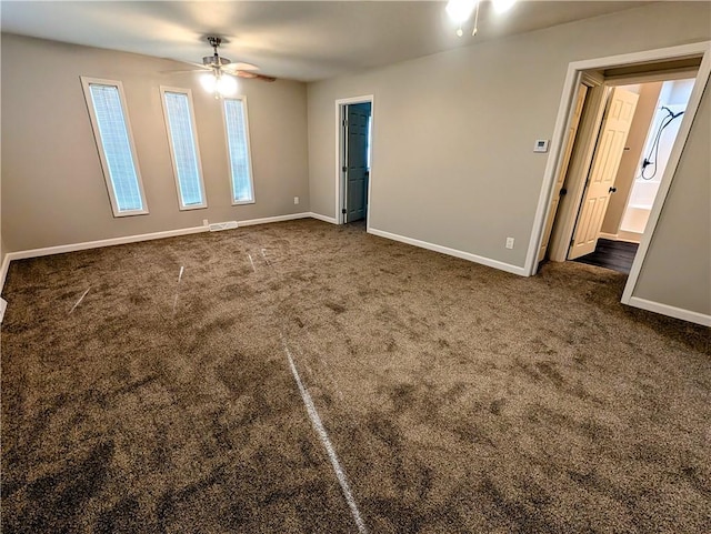 710 E Vine St, Iola, KS 66749 - empty room featuring a ceiling fan and dark carpet