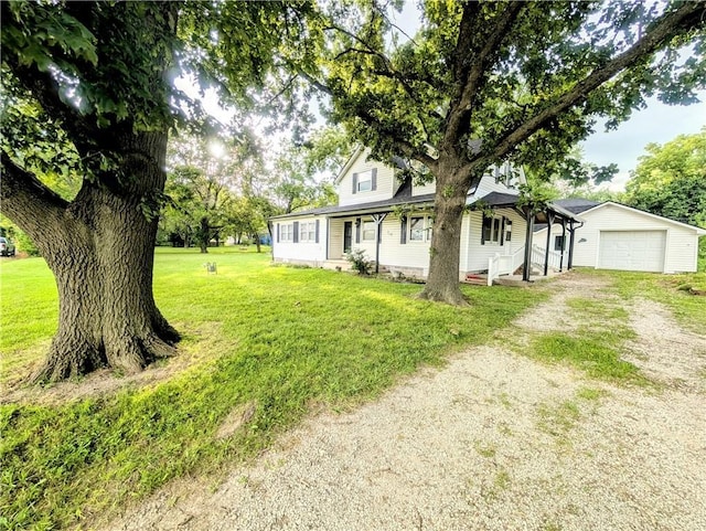 710 E Vine St, Iola, KS 66749 - view of front facade featuring dirt driveway, a front yard, and a detached garage