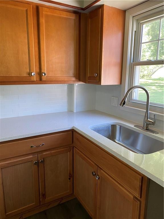 710 E Vine St, Iola, KS 66749 - kitchen with brown cabinetry and backsplash