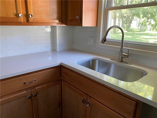 710 E Vine St, Iola, KS 66749 - kitchen with brown cabinets, backsplash, and light stone countertops