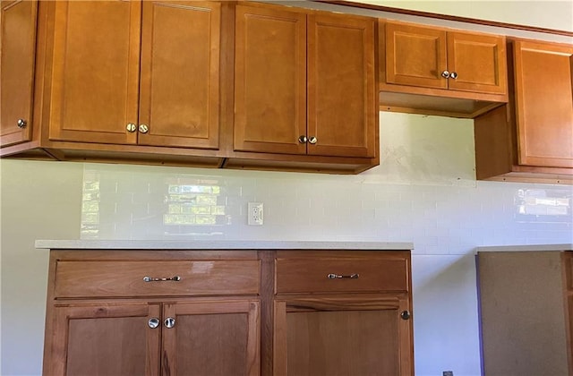 710 E Vine St, Iola, KS 66749 - kitchen with backsplash, brown cabinetry, and light countertops