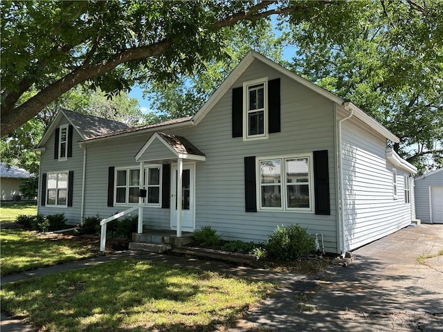 131 E Warren St, Gardner, KS 66030 - view of front of home with a front yard, a garage, an outbuilding, and driveway