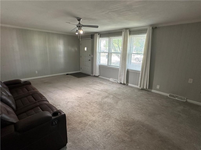 131 E Warren St, Gardner, KS 66030 - unfurnished living room with a ceiling fan, carpet, wooden walls, and crown molding
