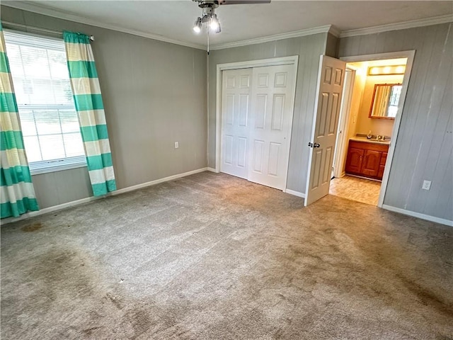 131 E Warren St, Gardner, KS 66030 - unfurnished bedroom with crown molding, carpet floors, a closet, wood walls, and a ceiling fan