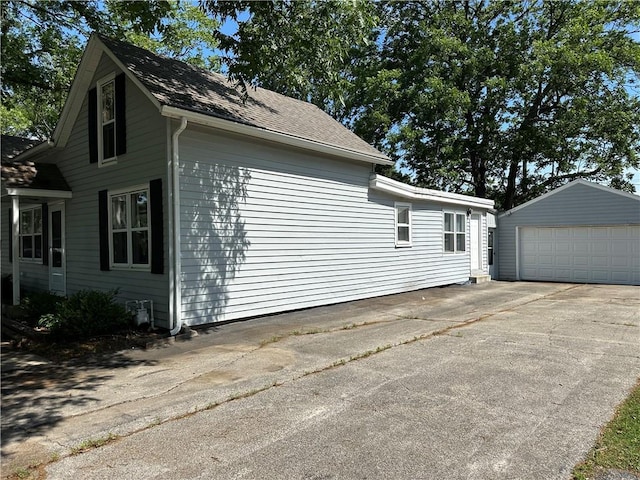 131 E Warren St, Gardner, KS 66030 - view of property exterior with an outdoor structure, a garage, and roof with shingles