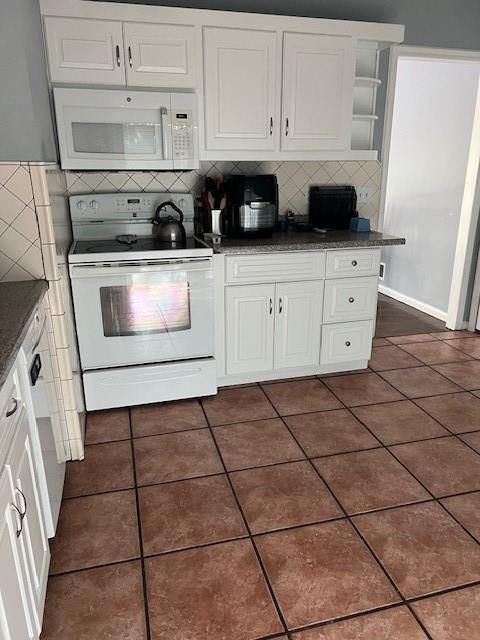 4301 James Ave, Independence, MO 64055 - kitchen featuring white appliances, open shelves, backsplash, white cabinetry, and dark tile patterned flooring