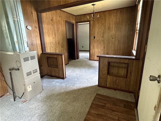 303 Bell St, Richmond, MO 64085 - hall featuring carpet flooring, wooden walls, heating unit, and a chandelier