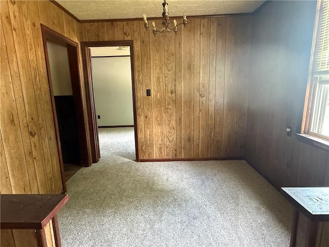 303 Bell St, Richmond, MO 64085 - unfurnished dining area featuring wooden walls, carpet, and a chandelier